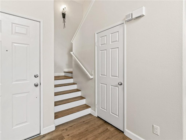 staircase with baseboards and wood finished floors