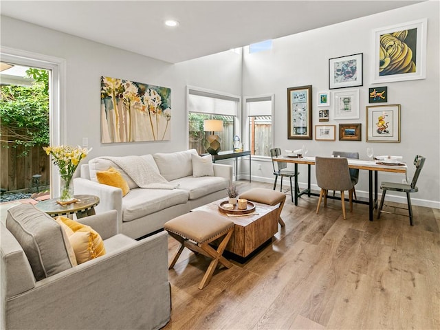 living area featuring recessed lighting, baseboards, and light wood-style floors