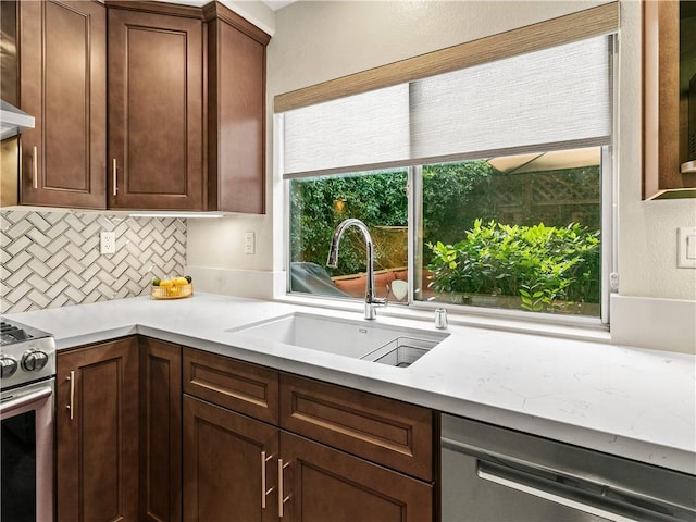 kitchen featuring light countertops, a sink, decorative backsplash, and stainless steel appliances