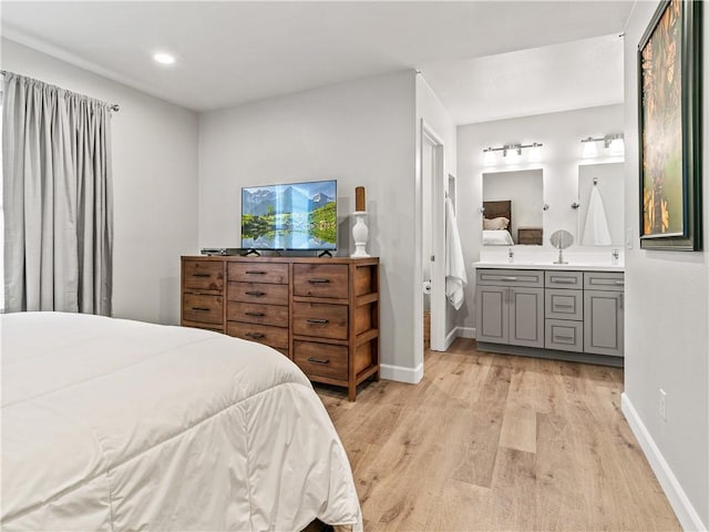 bedroom with connected bathroom, recessed lighting, baseboards, and light wood-type flooring