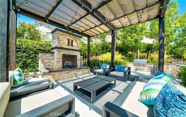 view of patio featuring area for grilling, exterior kitchen, and an outdoor living space with a fireplace