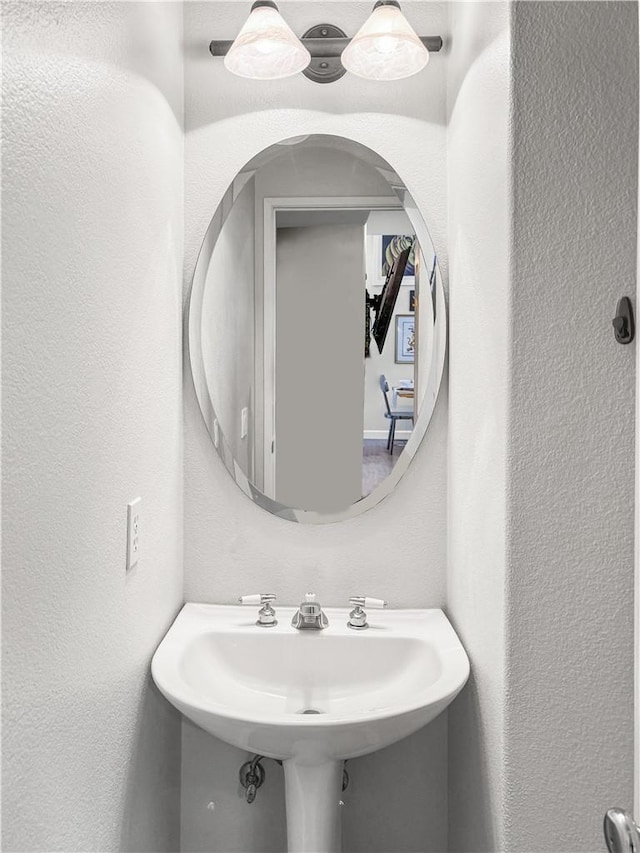 bathroom featuring a sink and a textured wall