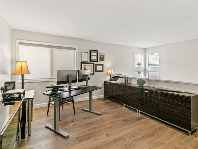 office space with baseboards and light wood-style floors