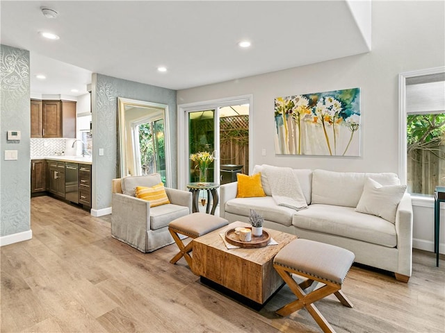 living room with recessed lighting, baseboards, and light wood-style floors