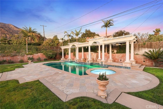 view of swimming pool with a pool with connected hot tub, a pergola, a patio, and a fenced backyard