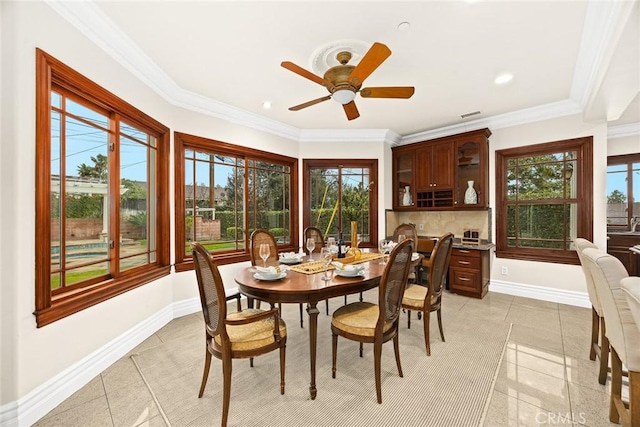 dining space with light tile patterned floors, a ceiling fan, ornamental molding, and baseboards