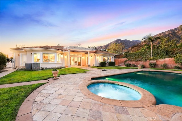 1774 Orangewood Ln, Arcadia, CA 91006 - pool at dusk with french doors, a fenced backyard, a mountain view, a pool with connected hot tub, and a patio
