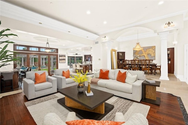 living area with ornamental molding, recessed lighting, arched walkways, and decorative columns