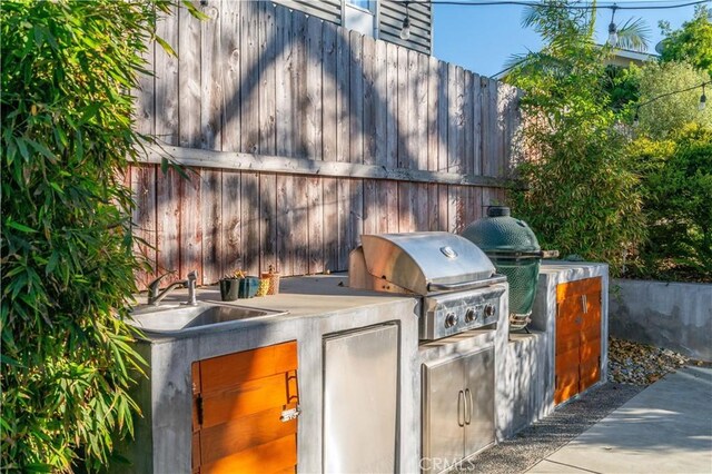 view of patio / terrace featuring an outdoor kitchen, fence, and area for grilling