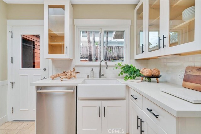 bar with stainless steel dishwasher, a sink, and backsplash