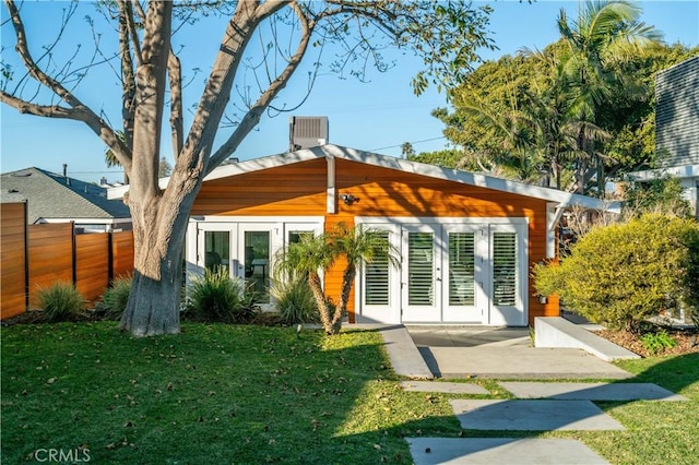back of house with a lawn, french doors, and fence
