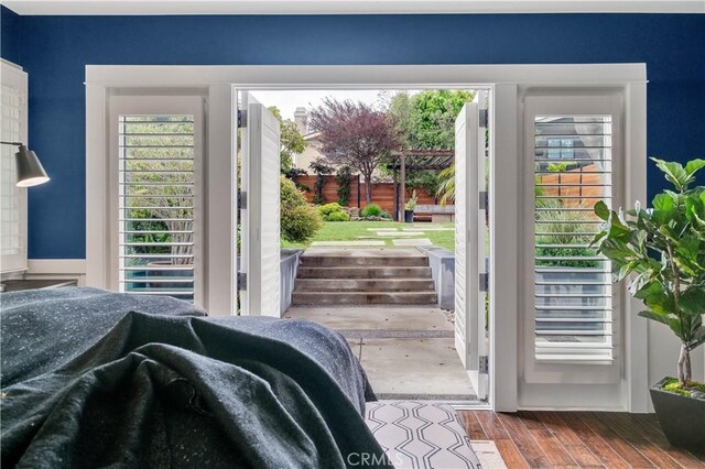 bedroom with wood finished floors and multiple windows