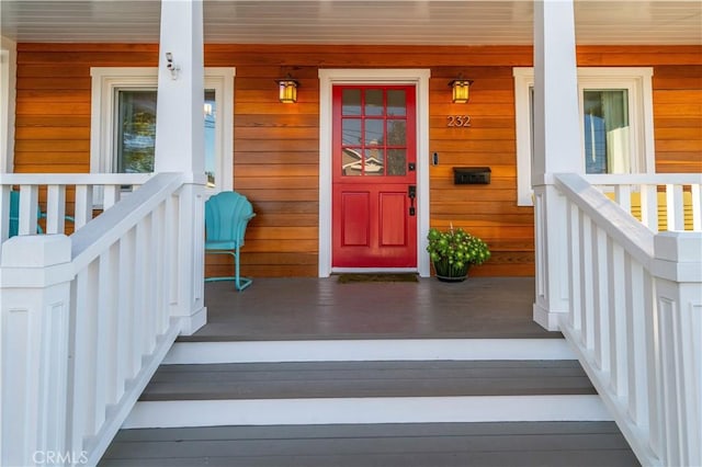 view of exterior entry featuring covered porch