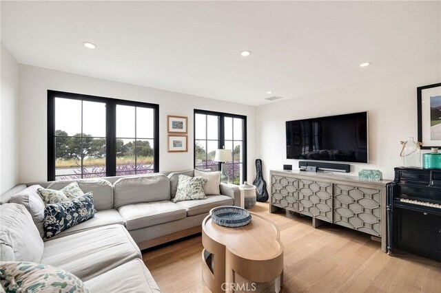 living area with visible vents, recessed lighting, and light wood-style flooring