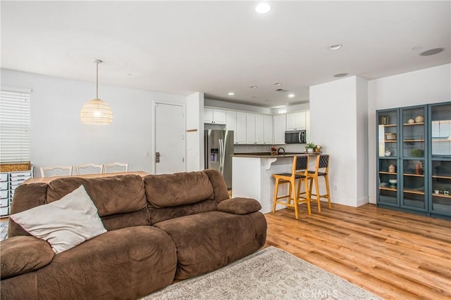 living area with recessed lighting, light wood finished floors, and baseboards