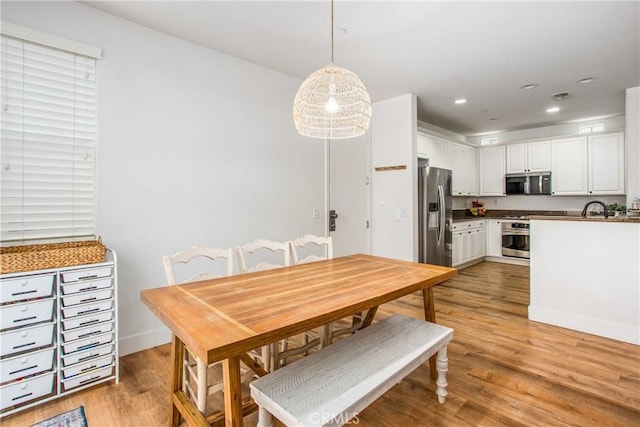 dining room featuring recessed lighting, baseboards, light wood finished floors, and visible vents