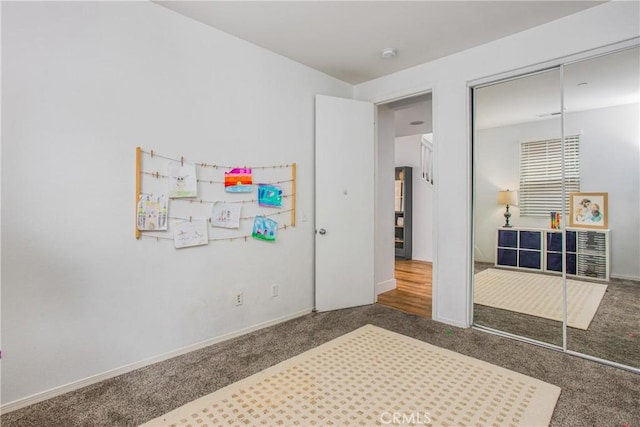 bedroom with baseboards, carpet, and a closet