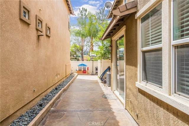 view of home's exterior with a patio, stucco siding, and fence