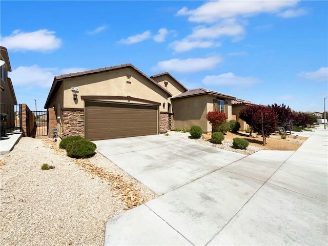 ranch-style house with stone siding, stucco siding, a gate, an attached garage, and driveway