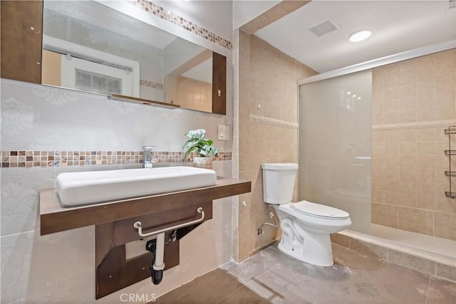 full bath with a shower stall, visible vents, toilet, tile walls, and tile patterned floors