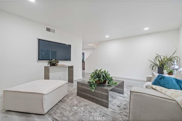 living room with baseboards, visible vents, and recessed lighting