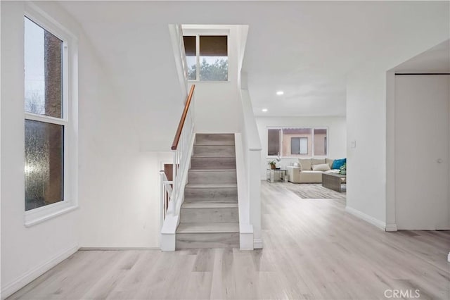 stairway with baseboards, recessed lighting, and wood finished floors