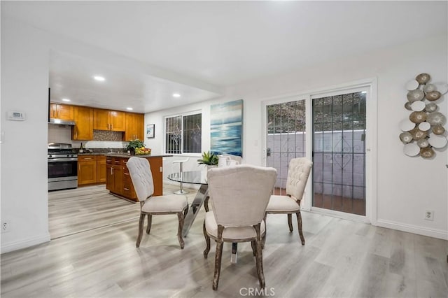 dining room with light wood finished floors, recessed lighting, and baseboards
