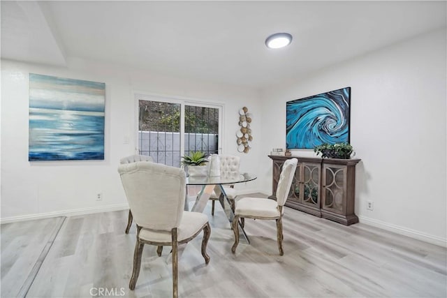 dining space with wood finished floors and baseboards