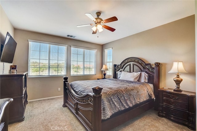 bedroom featuring light colored carpet, visible vents, baseboards, and multiple windows