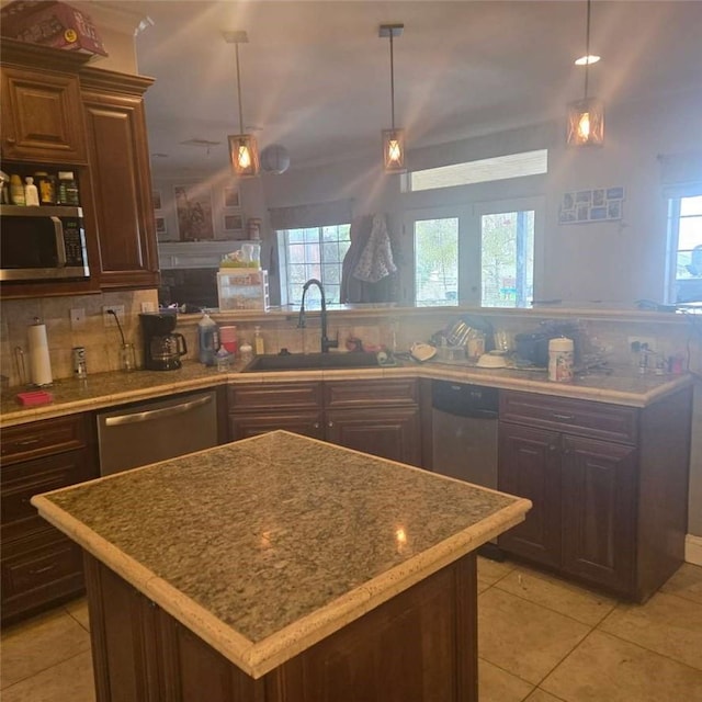 kitchen featuring a sink, stainless steel appliances, light tile patterned floors, a wealth of natural light, and tasteful backsplash