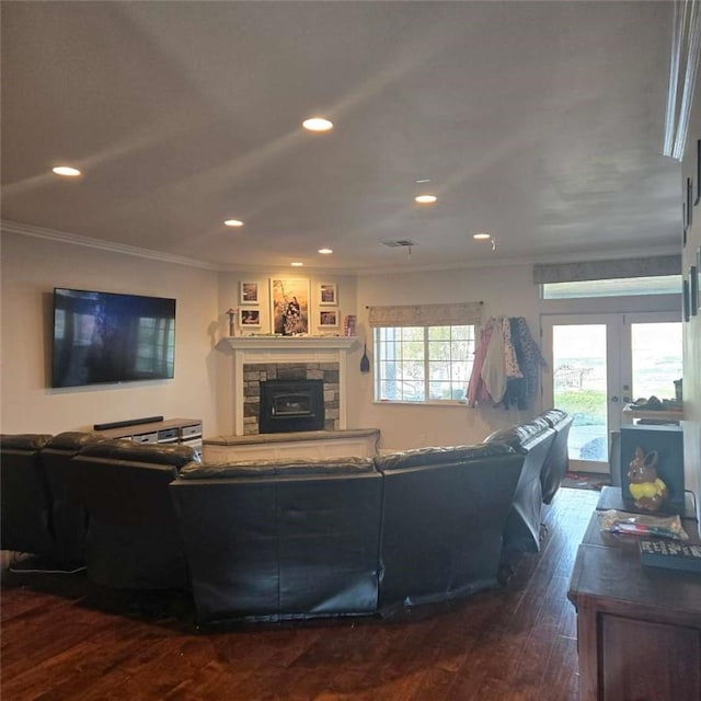 living room featuring recessed lighting, a stone fireplace, ornamental molding, french doors, and dark wood finished floors