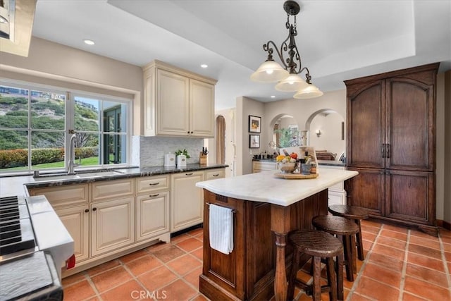 2839 Via Victoria, Palos Verdes Estates, CA 90274 - kitchen featuring cream cabinetry, a sink, arched walkways, recessed lighting, and a breakfast bar area
