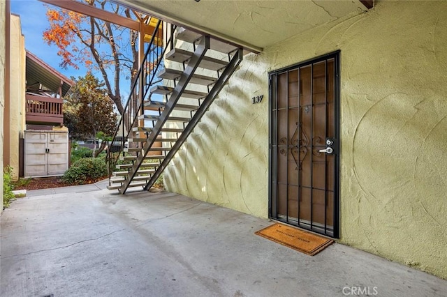 doorway to property featuring stucco siding and a patio