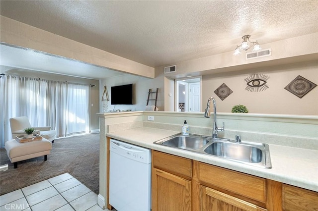 kitchen featuring visible vents, open floor plan, dishwasher, and a sink