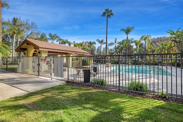 community pool featuring a lawn and fence