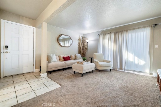tiled living area featuring a textured ceiling and carpet