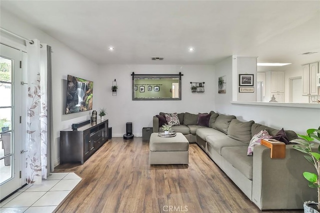 living area featuring recessed lighting, visible vents, wood finished floors, and baseboards