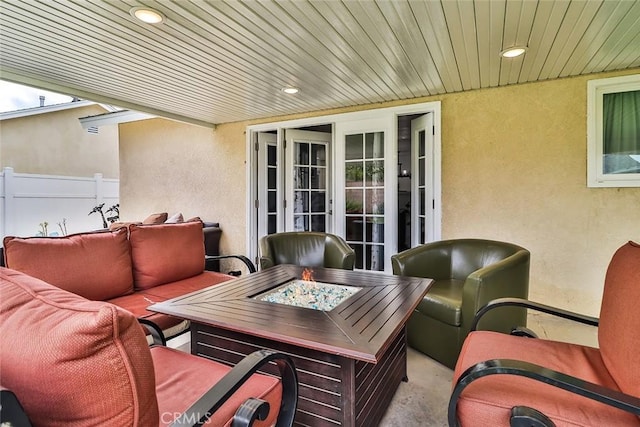 view of patio / terrace featuring fence and an outdoor living space with a fire pit