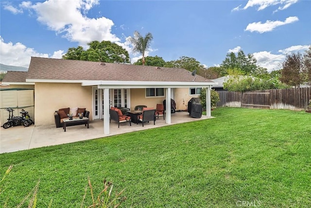 back of house with a fenced backyard, stucco siding, a patio area, and a lawn