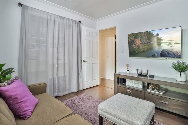 living area featuring wood finished floors and crown molding