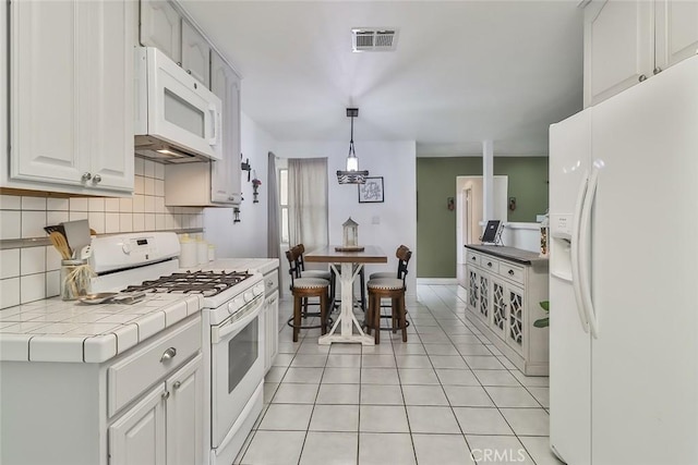 2241 Stinson St, Simi Valley, CA 93065 - kitchen with white appliances, tile countertops, tasteful backsplash, light tile patterned flooring, and decorative light fixtures