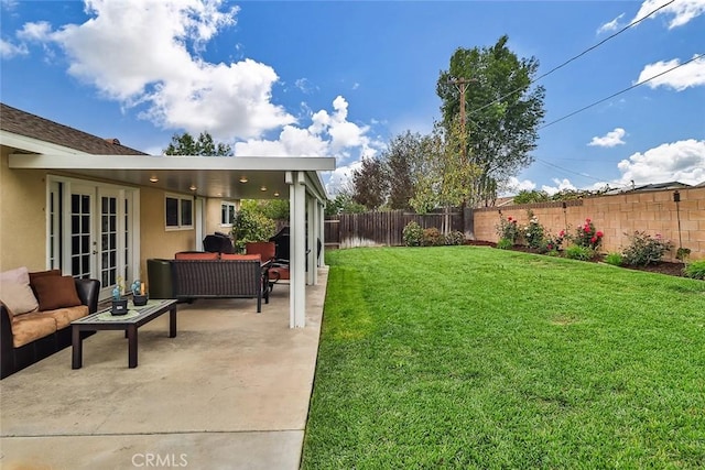 view of yard with a patio, an outdoor living space, a fenced backyard, and french doors