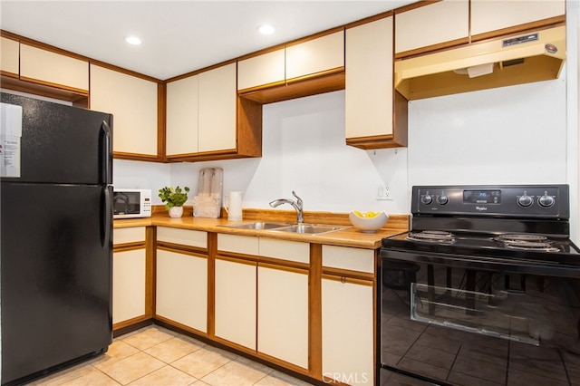 kitchen featuring light tile patterned floors, a sink, light countertops, under cabinet range hood, and black appliances
