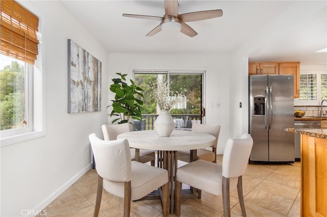 dining room featuring light tile patterned floors, a ceiling fan, and baseboards