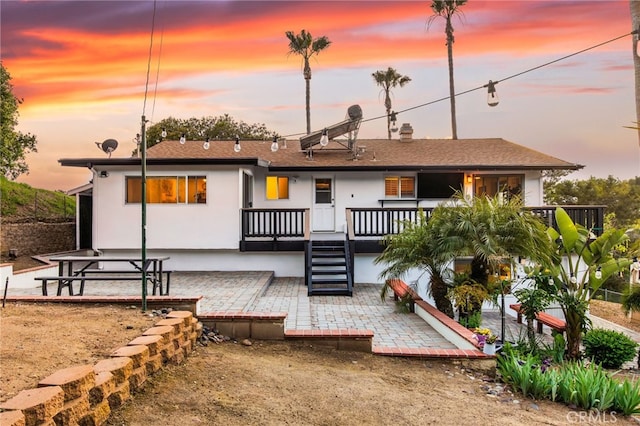 rear view of house featuring stucco siding and a patio area