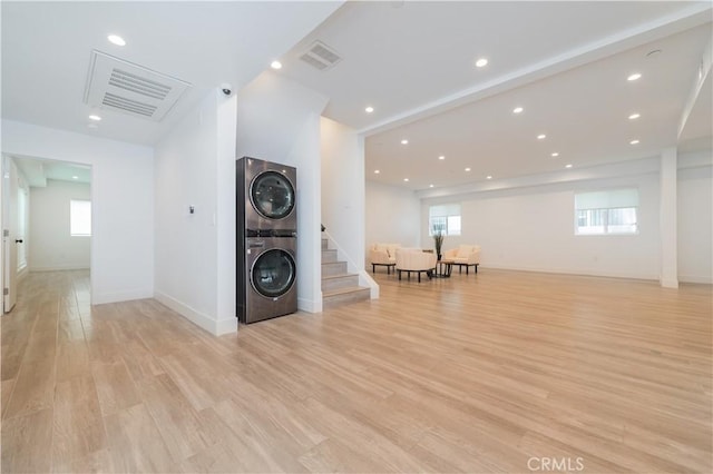 1444 W 37th St, Los Angeles, CA 90018 - living area featuring light wood-type flooring, visible vents, stairway, and stacked washer and dryer