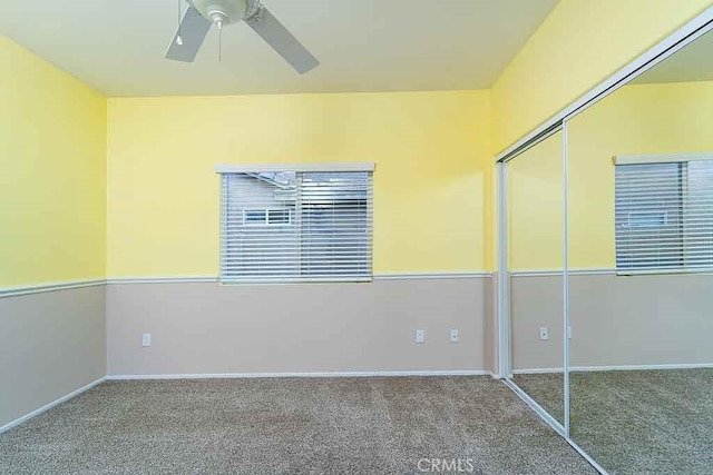 unfurnished bedroom with ceiling fan, baseboards, carpet flooring, and a closet