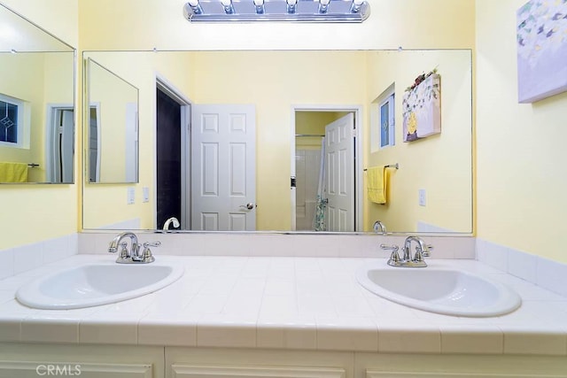 full bathroom featuring double vanity and a sink