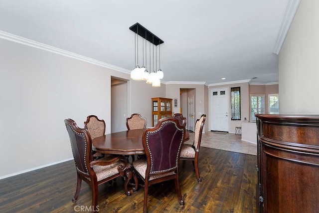 dining area featuring dark wood-type flooring, baseboards, and crown molding