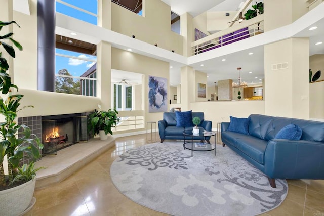 1710 Via Allondra, San Marcos, CA 92078 - tiled living area featuring visible vents, ceiling fan, a high ceiling, and a warm lit fireplace